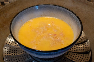 Pour egg mixture on top of the steamed meat layer