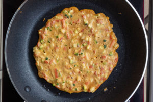 The pancake is ready to flip when the small bubbles become large bubbles, and the batter on top begins to set