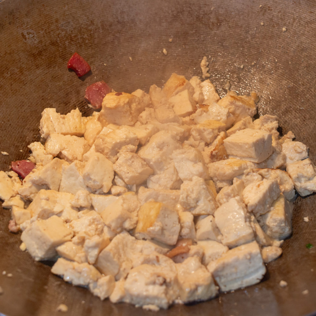 Tofu frying in rendered fat