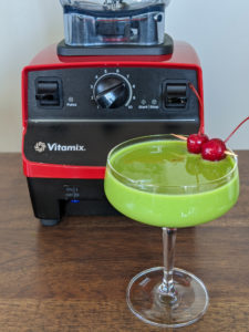 Vitamix green smoothie: soy milk, spinach, and pineapple garnished with a cherry