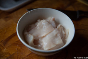 White fish fillets marinating in Shaoxing wine, corn starch, and egg white