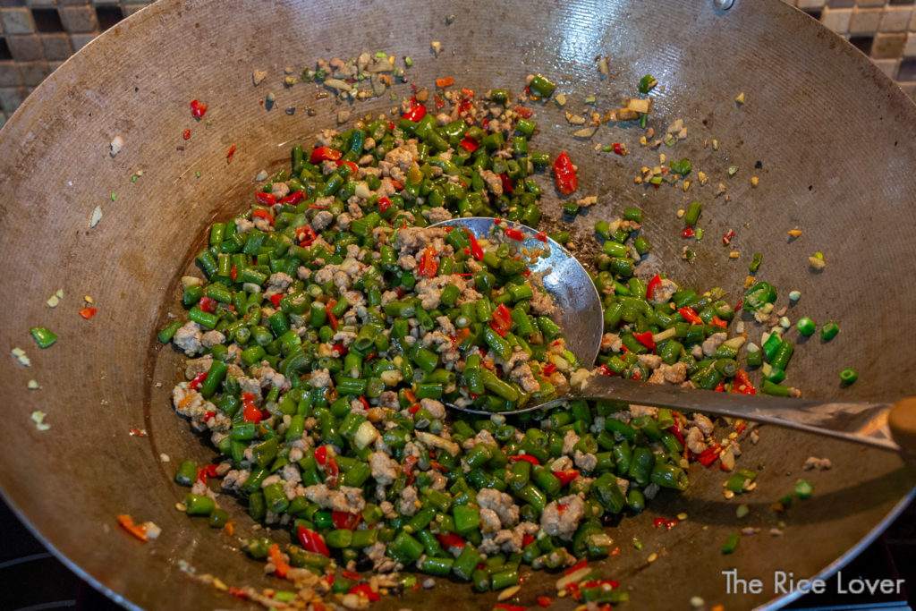 Saute long bean or green bean segments, then add seasoning