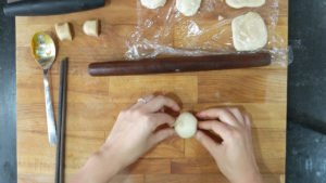Fold the rolled dough in half, and pinch the sides to form a ball