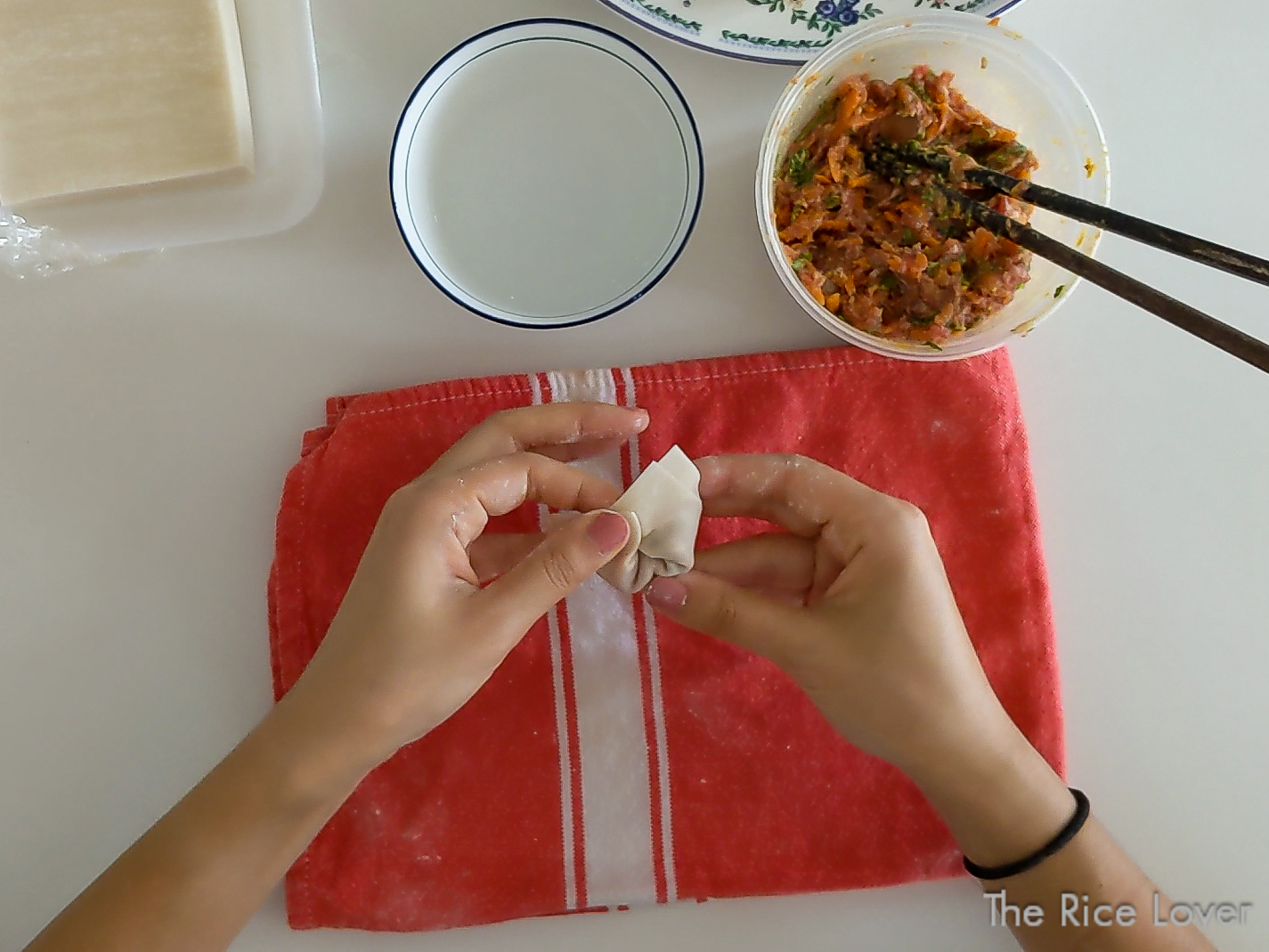 Pinch together two edges on the same long side to form the wonton