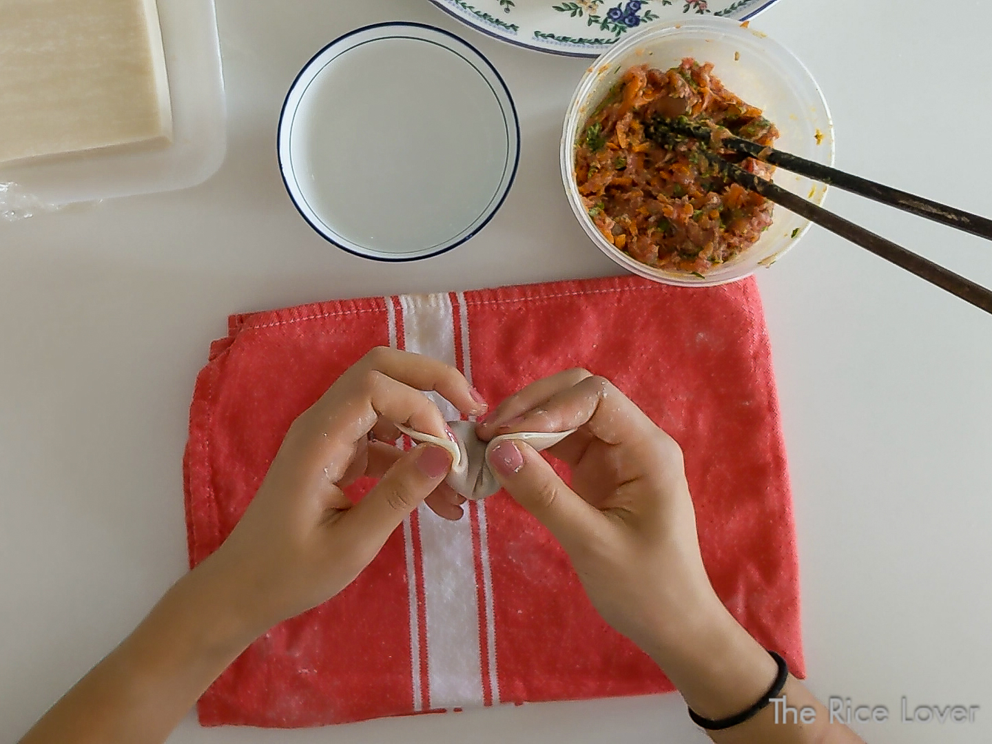 Pinch together two edges on the same long side to form the wonton