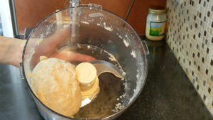Slowly stream the water into the food processor and run until it forms a ball